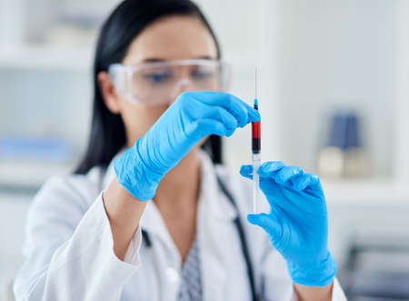 What does this patients blood say about their health. Shot of a young scientist conducting an experiment in a laboratory.の写真素材