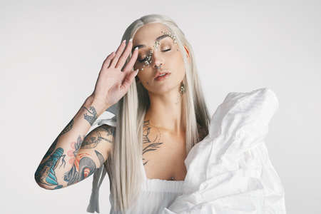 Never conform to the norm. Cropped shot of an attractive young woman posing with her eyes closed against a grey background in studio.の写真素材