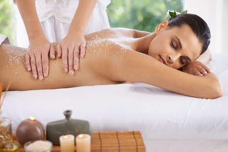 Life doesnt get better than this. Shot of a young woman enjoying a massage at a spa.の写真素材