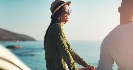 Youre the reason I smile. Cropped shot of a young couple making a stop at the beach while out on a road trip.の写真素材