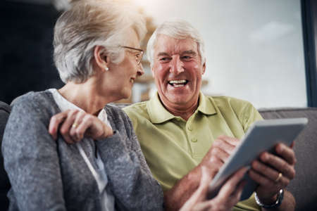 Its a laugh a minute on the internet. Shot of a senior couple using a digital tablet together on the...