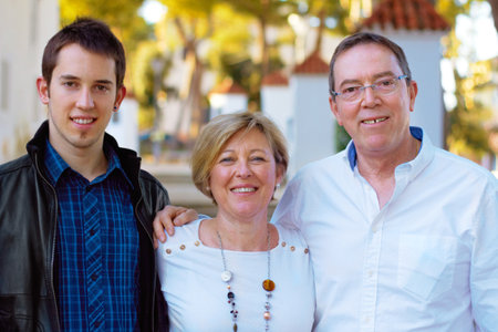 Happy families. Portrait of a couple and their son standing outdoors.