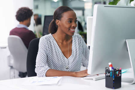 She thoroughly enjoys her job. Shot of a businesswoman working in an office.