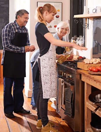 Youre never to old to learn how to cook. Shot of two senior woman watching a young woman cooking on...
