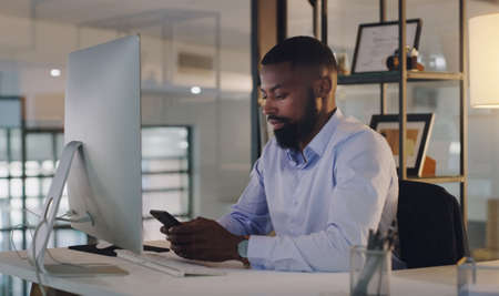 Keeping up with his connections at all hours. Shot of a young businessman using a cellphone while...