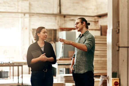 Were always discussing ways of growing our business. Cropped shot of two young carpenters at work in...