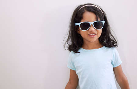Mom says Im the coolest kid on the block. Shot of an adorable little girl wearing sunglasses while...