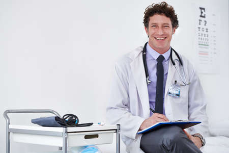 Youre in good hands. Portrait of a male doctor reading a report.