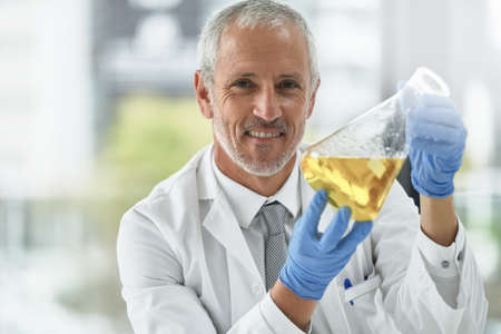 I think ive got a breakthrough. Portrait of a researcher working with beakers in a lab.