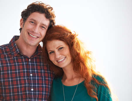 Their love is radiant. Portrait of a happy and loving young couple standing indoors.
