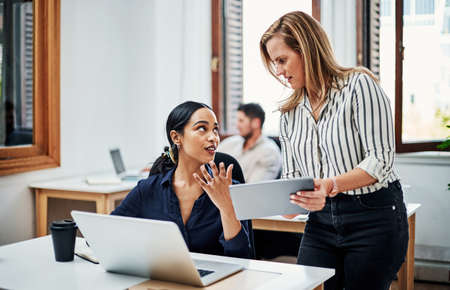 Lets go over this. Cropped shot of an attractive businesswoman helping a female colleague in the...