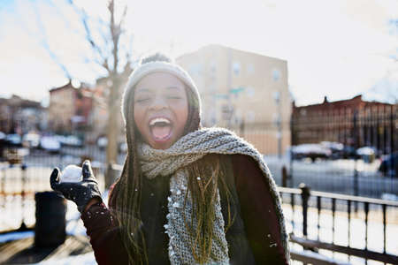 First rule of winter Have a snowball fight. Shot of a beautiful young woman throwing a snowball on a wintery day outdoors.の写真素材