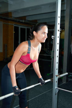 Molding her body. Shot of an attractive young woman pumping iron in the gym.