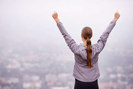 Feeling on top of the world in the morning. Rearview shot of a woman training outdoors with her arms...