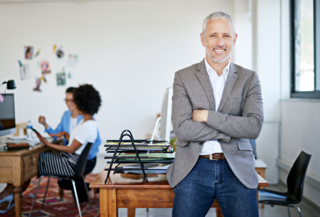 Ive got one of the best teams behind me. Portrait of a mature businessman standing in an office.の写真素材
