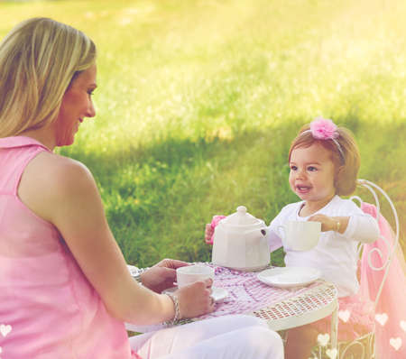 Let me pour you a cuppa. Shot of a mother and her cute little girl having a tea party on the lawn...