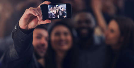 One last selfie for the year. Cropped shot of a group of young friends taking selfies while dancing...