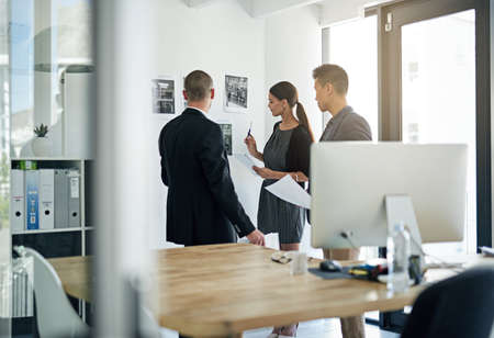 Going over their strategy. Cropped shot of three colleagues working in the office.の写真素材