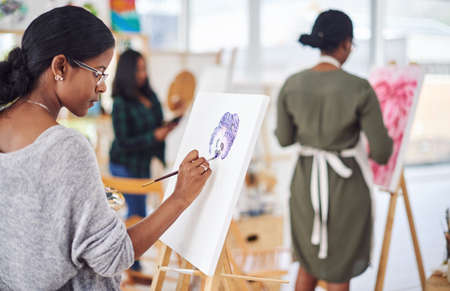 Enjoying another art session. Defocused shot of a group of people painting in a art studio.の写真素材