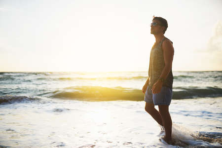 As free as the ocean. Shot of a young man spending the day at the beach.の写真素材