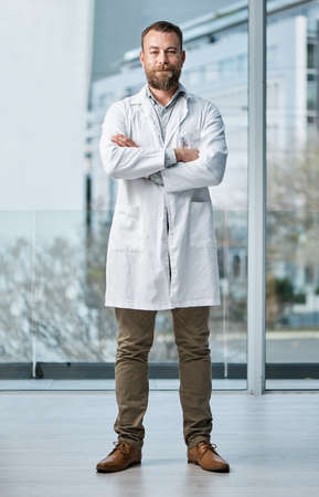 Doctors form a strong pillar in the healthcare system. Portrait of a medical practitioner standing in a hospital.の写真素材