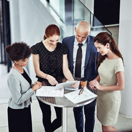 Running their business meeting on a new app. Shot of a corporate business team using a digital...