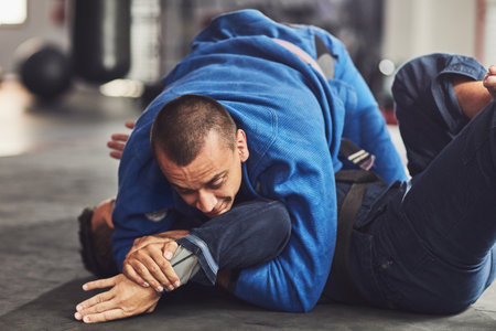 Hes got him pinned. Cropped shot of two professional fighters sparring in the gym.の写真素材