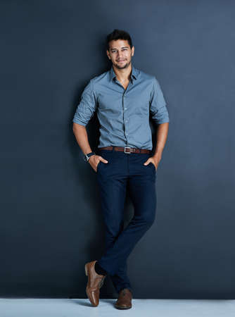 The successful always drive their ambition into their performance. Studio portrait of a confident young businessman posing against a dark background.の写真素材