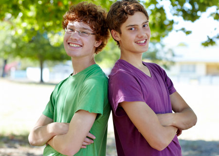 Weve got each others backs. Portrait of two boys standing back to back outdoors on a sunny day.