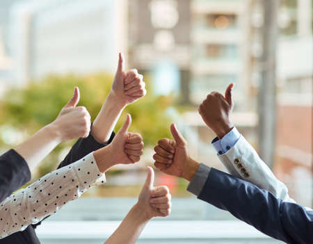 Exceptional work. Cropped shot of a group of businesspeople showing a thumbs up gesture.