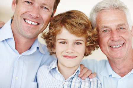 Family ties. Cropped portrait of a young boy standing with his father and grandfather.の写真素材