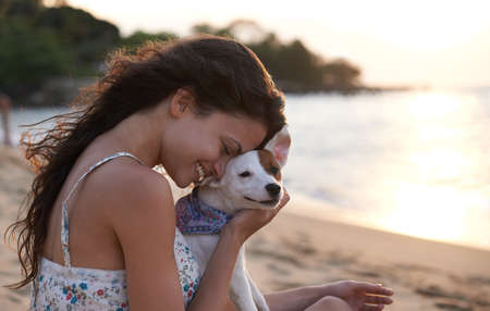 Youre my good boy. Shot of an attractive young woman enjoying the beach with her dog.の写真素材