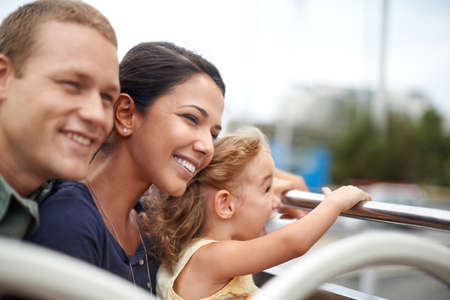 A family is a little world created by love. A young family seeing the city on the top of a bus.の写真素材