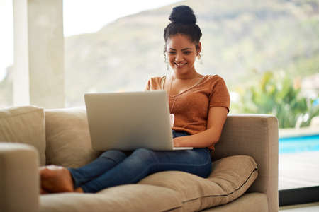 All these status updates on social media is too funny. Shot of a beautiful young woman sitting on a...