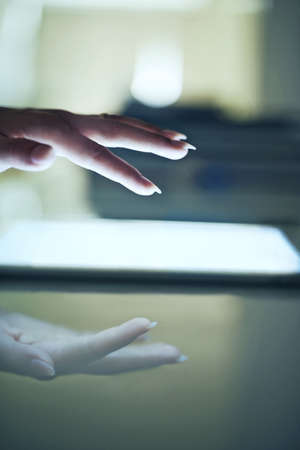 Data at her touch. Closeup of a young woman holding a touch sensitive digital tablet.の写真素材