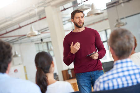Speak with confidence. Shot of designer giving a presentation to his colleagues using a digital...