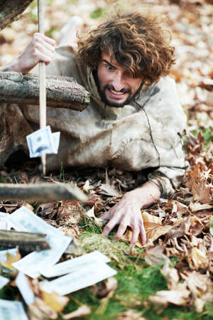 These leaves dont belong here. A crazy looking caveman crawling on the ground and piercing money...