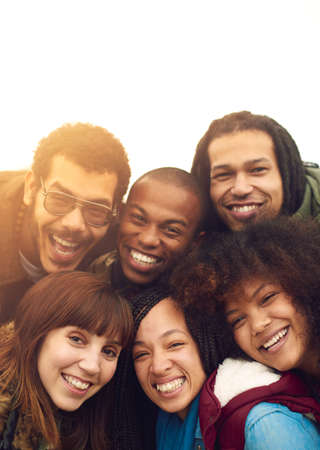 Friends are the family we choose. Portrait of a happy group of friends posing together outside.