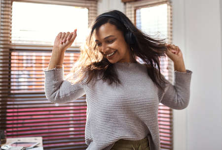 And if the music is good, you dance. Shot of a young woman dancing while listening to music at home.