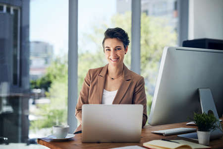 To see success, youve got to work hard. Portrait of a businesswoman working on a laptop in an office.の写真素材