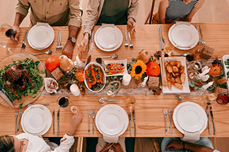 Gather around the table, its time to give thanks. High angle shot of a group of friends having a Thanksgiving meal together.の写真素材