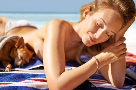 Now this is paradise. Shot of an attractive young woman enjoying a vacation at the beach.の写真素材