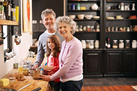 Baking day with Nan and Gramps. Portrait of a little girl and her grandparents baking together in...