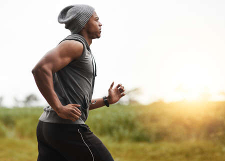 Run your day before it runs you. Shot of a healthy young man out for a run in nature.
