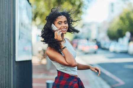 I cant get through the city without my cellphone. Shot of an attractive young woman on a call in the...
