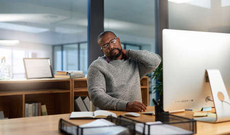 Ive clearly been sitting here for too long. Cropped shot of a handsome mature businessman sitting at...