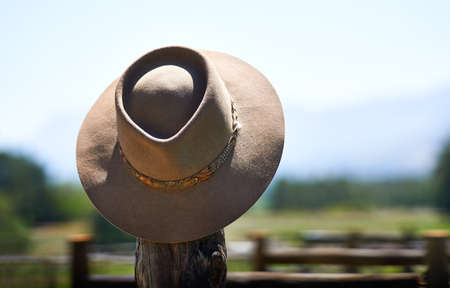 Hats off to you. Shot of a wide brimmed hat on a fence post.の写真素材