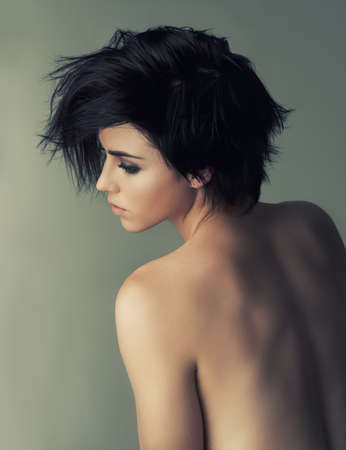 Tender beauty. Rearview studio shot of an attractive woman looking over her bare shoulder.の写真素材