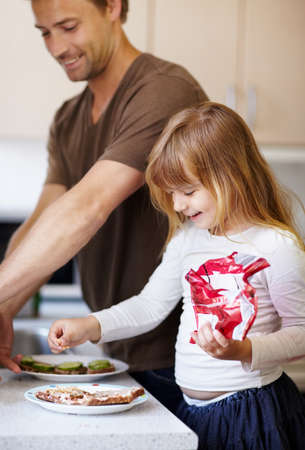 Bonding over breakfast. A little girl making breakfast with her father.の写真素材