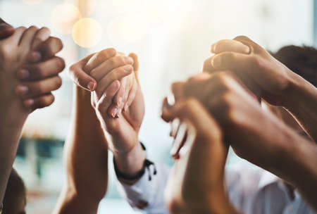 We need to encourage and uplift one another. Closeup shot of a group of businesspeople holding hands...